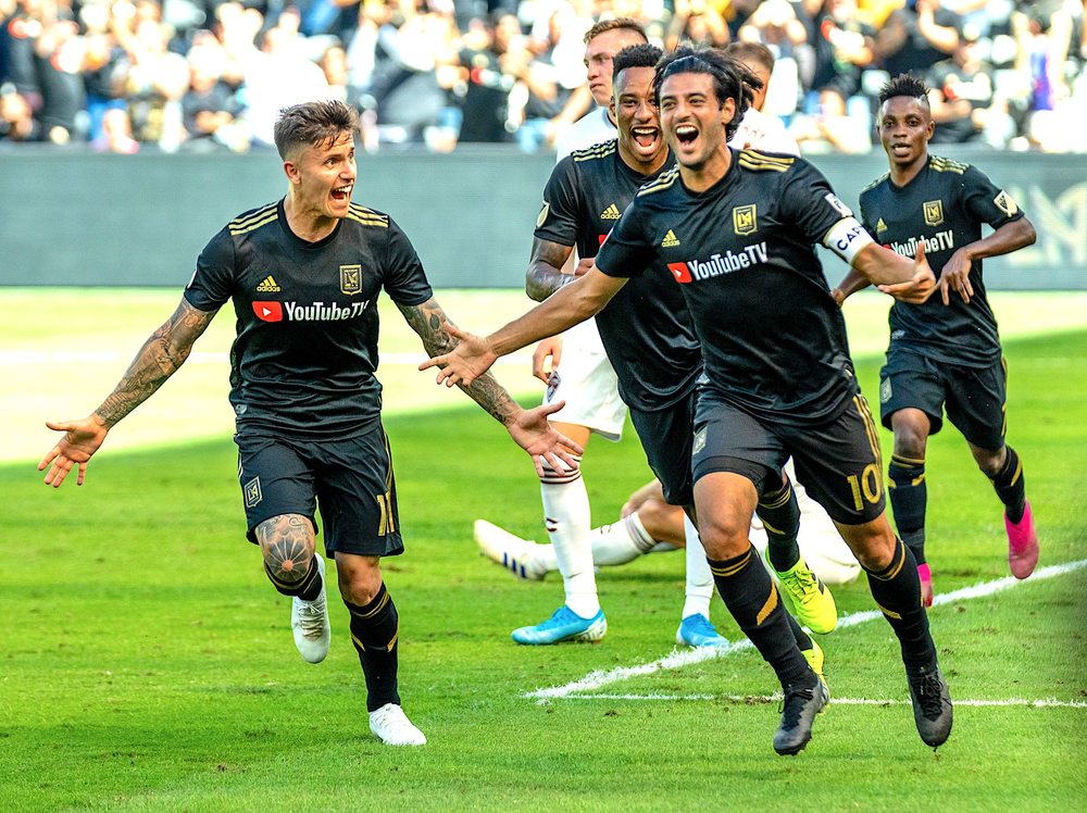 Los Angeles FC forward Carlos Vela, center, holds up the